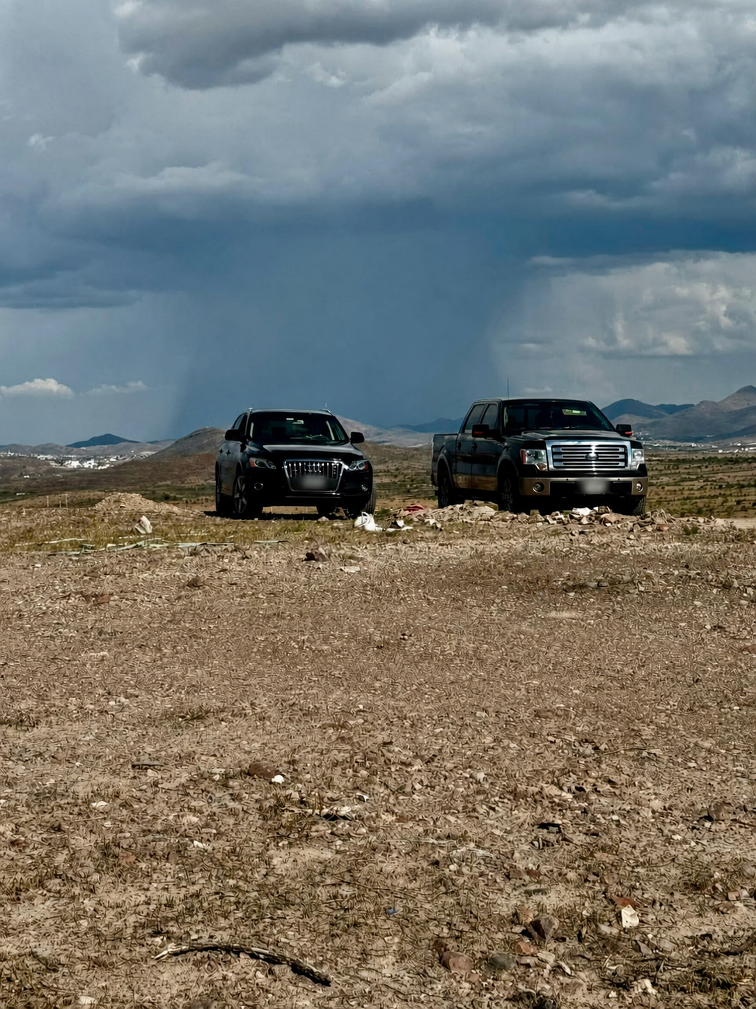 Vehículos recorriendo el terreno de Rancho La Haciendita bajo un cielo tormentoso